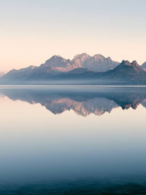 Alpsko jezero sa odrazom planinskih vrhova u zori